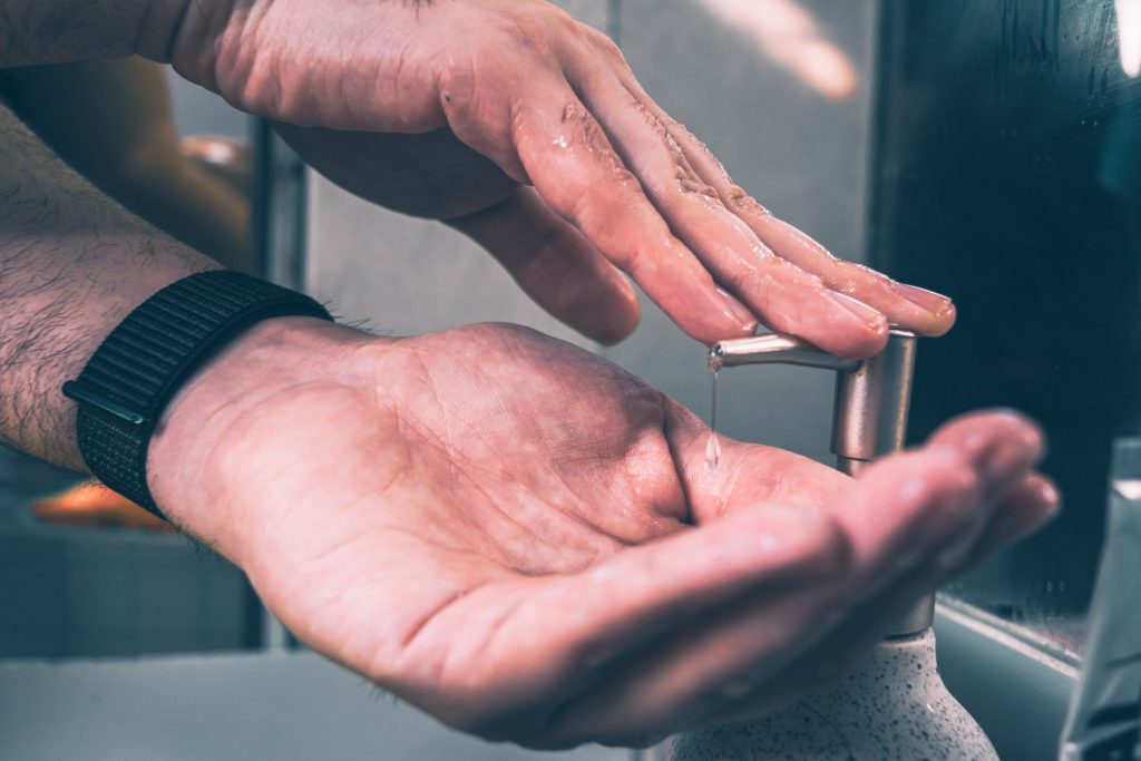 A person applying soap to their hands. 